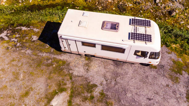 Camper van with solar panels on roof in summer mountains landscape